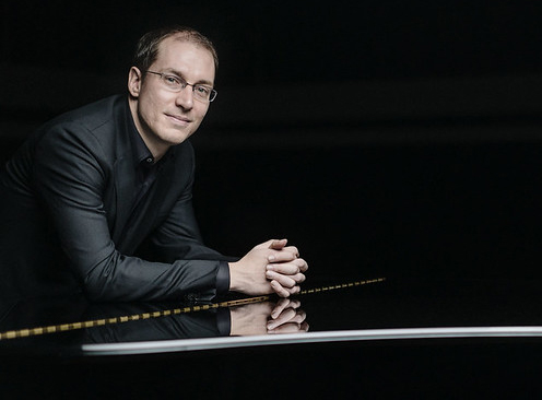 image of Gilles Vonsattel leaning over shiny black piano