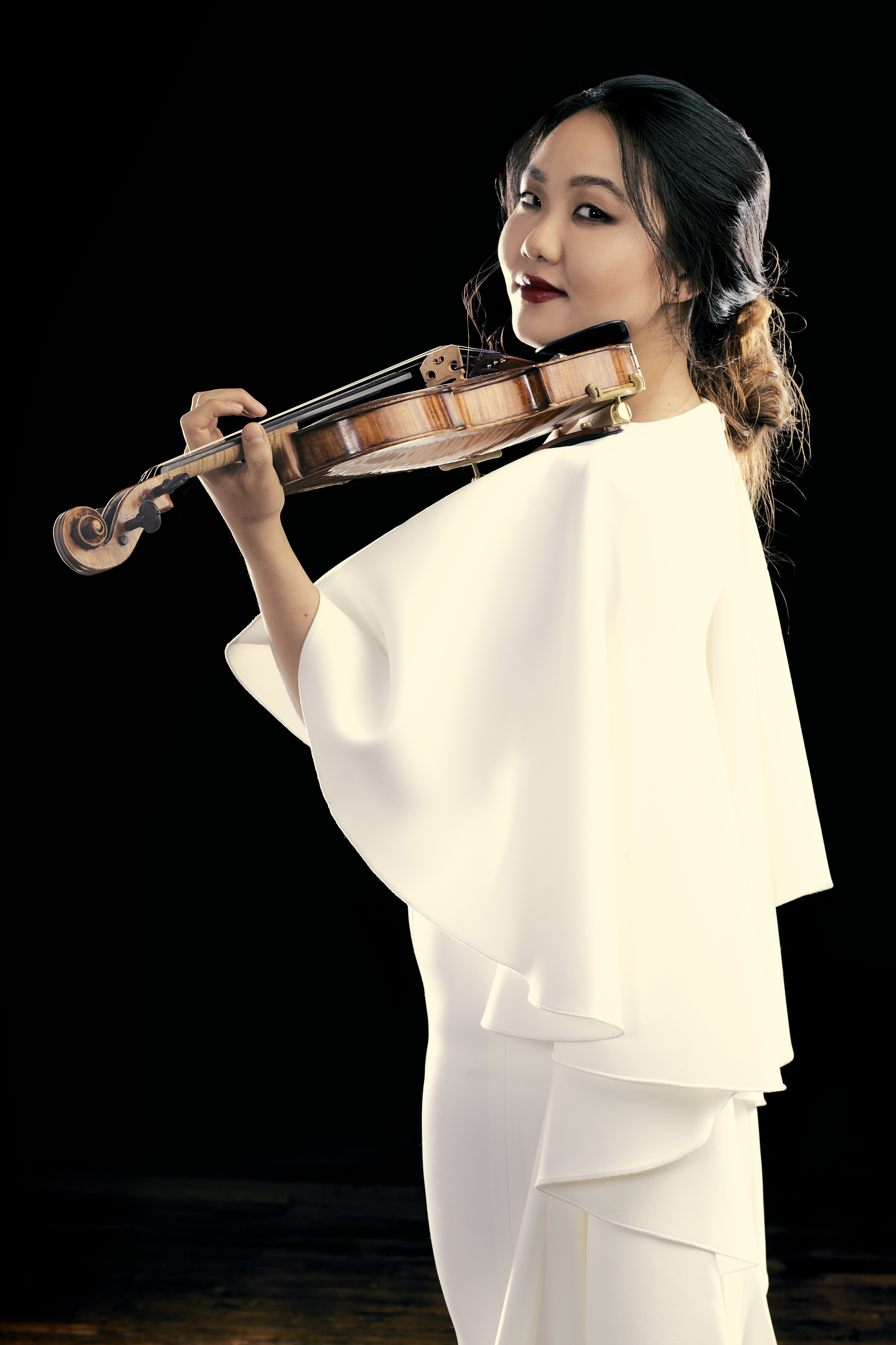 image of Stella Chen in white gown holding violin in playing position