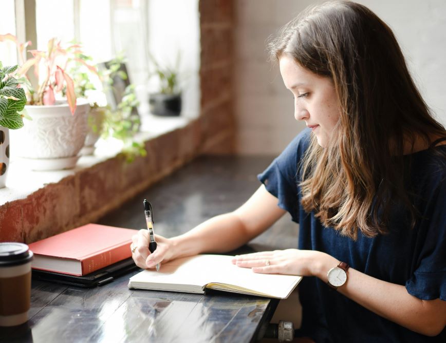 Person reflecting and writing in journal