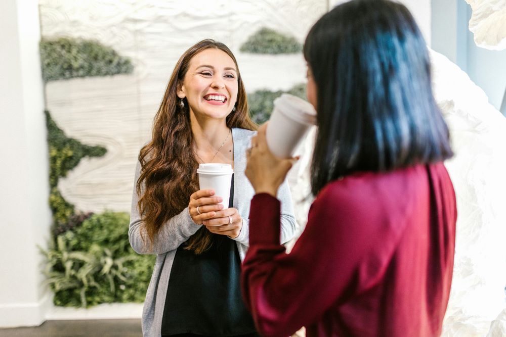 two coworkers chatting over coffee