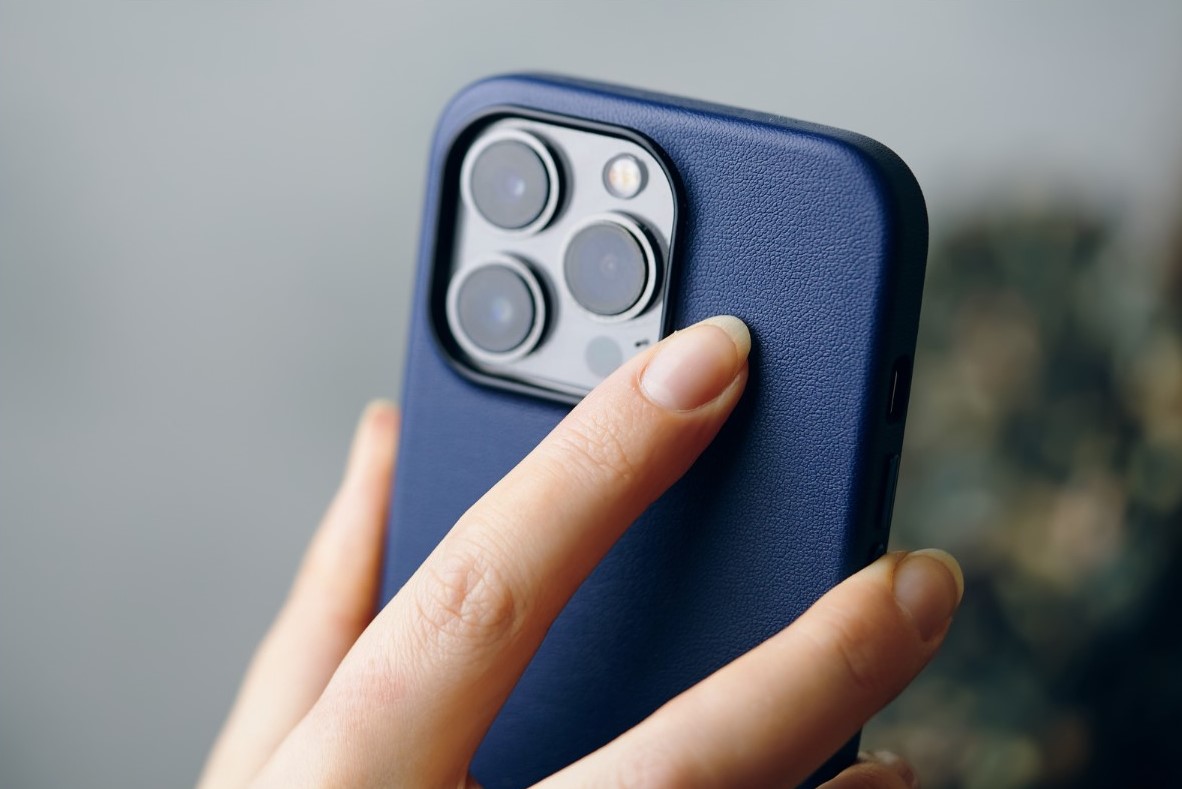 iPhone being held by human hand, camera facing viewer.