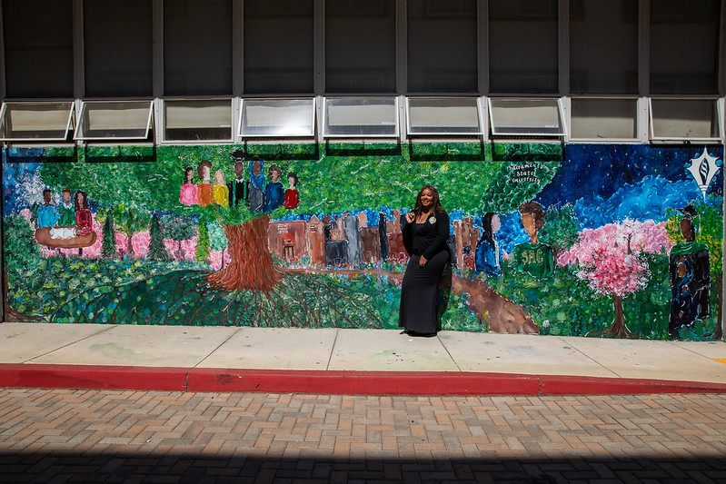 Adia Williams in front of her mural