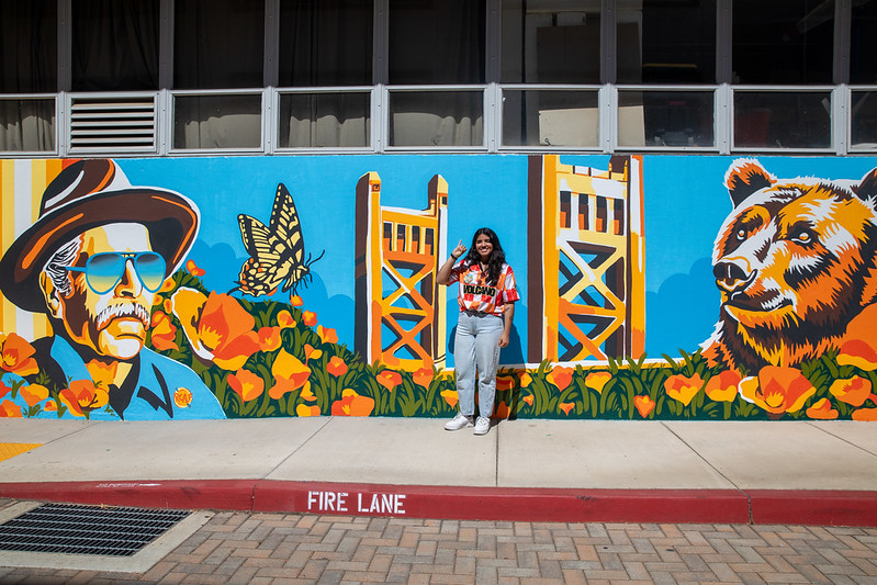 Alejandra Ruiz in front of her mural