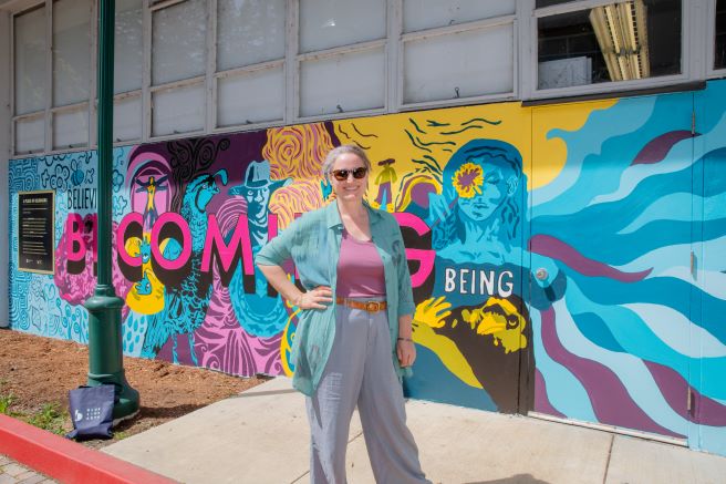 Heather Hogan in front of Becoming Mural