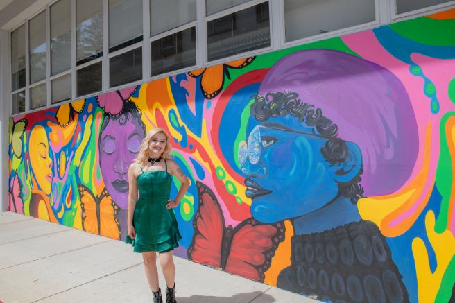 Jaci Zemenchik in front of Becoming Mural