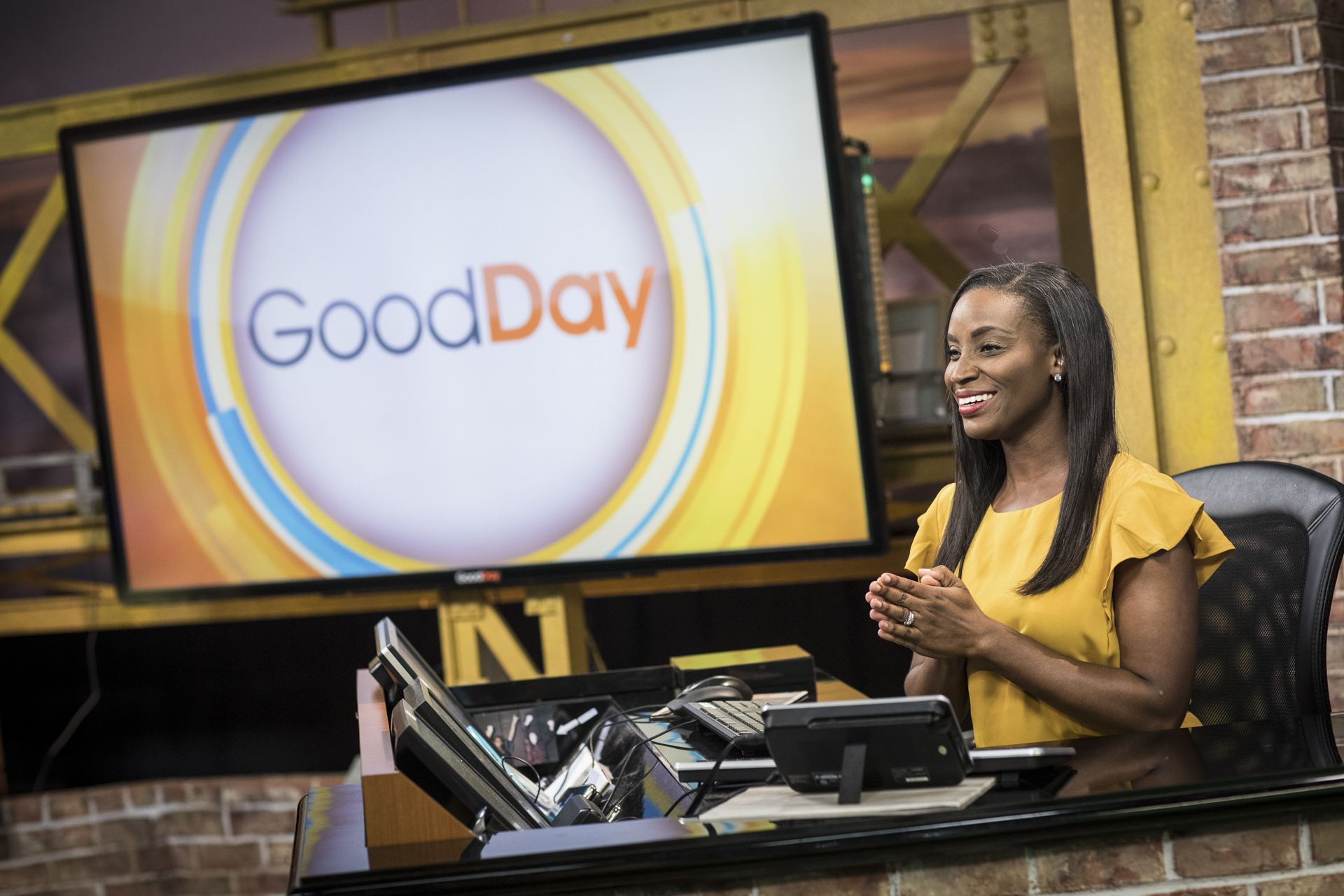 Courtney Dempsey sitting at the anchor desk on the set of Good Day Sacramento.