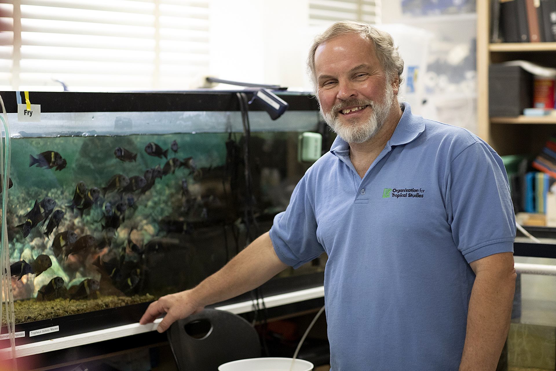 Ron Coleman, standing next to a fish tank