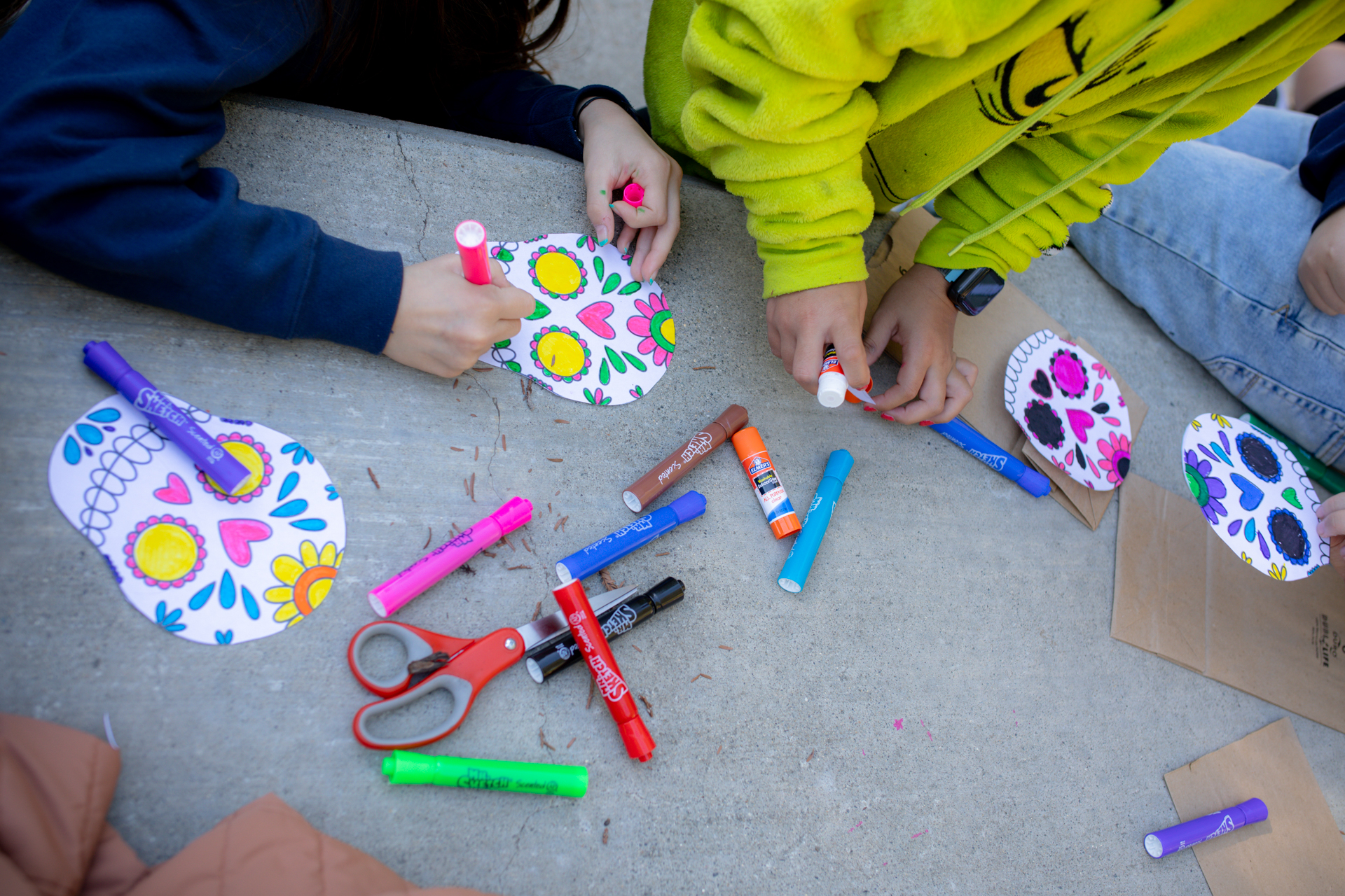 Paper outlines of sugar skulls, decorated by children.