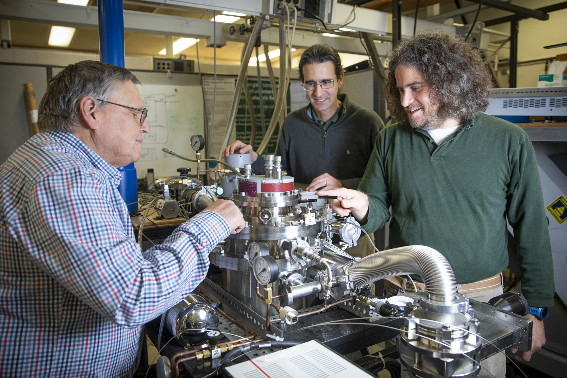 Physics professors work on equipment in a Sac State lab.