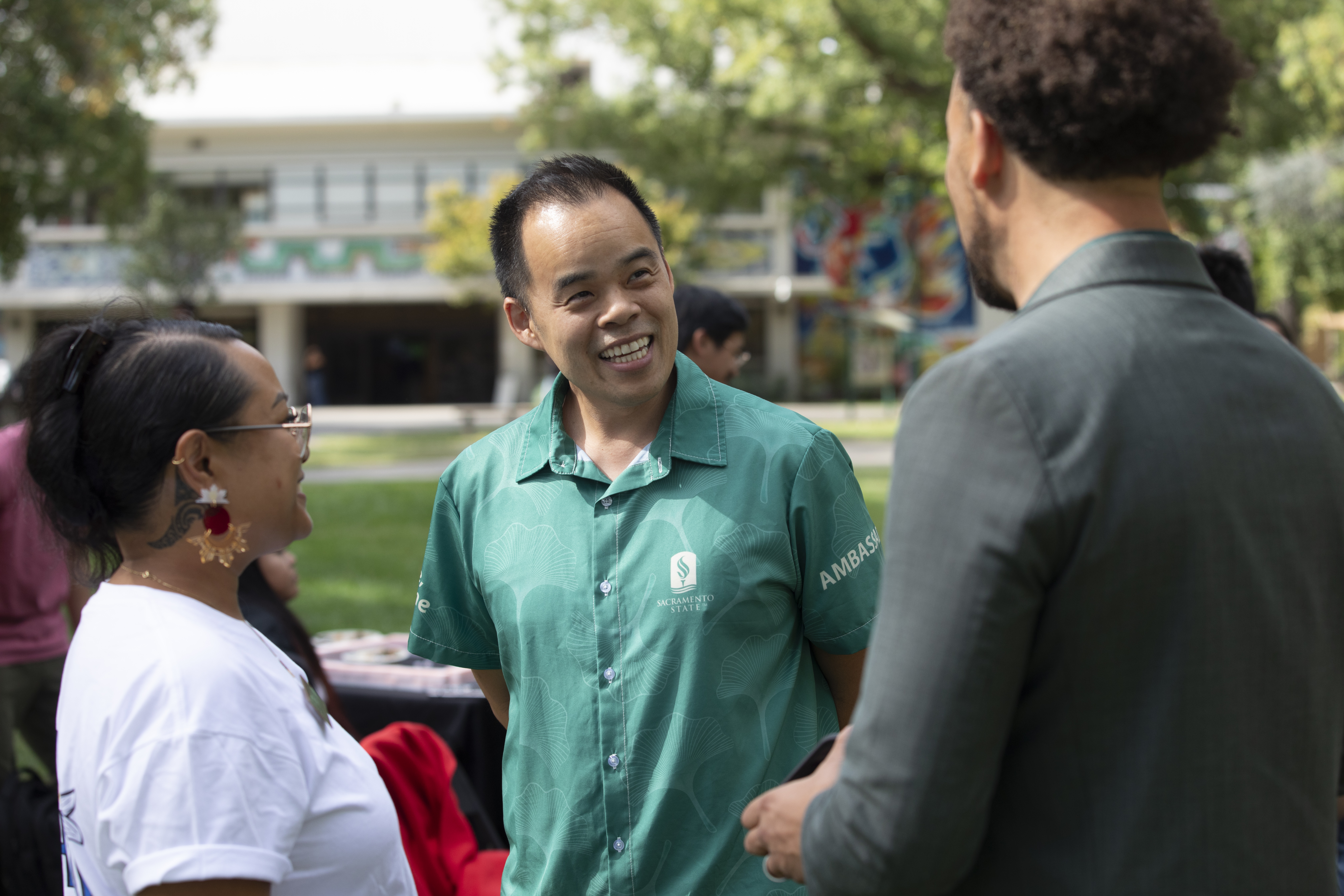 A photo of Michael Nguyen smiling and chatting with President Wood.