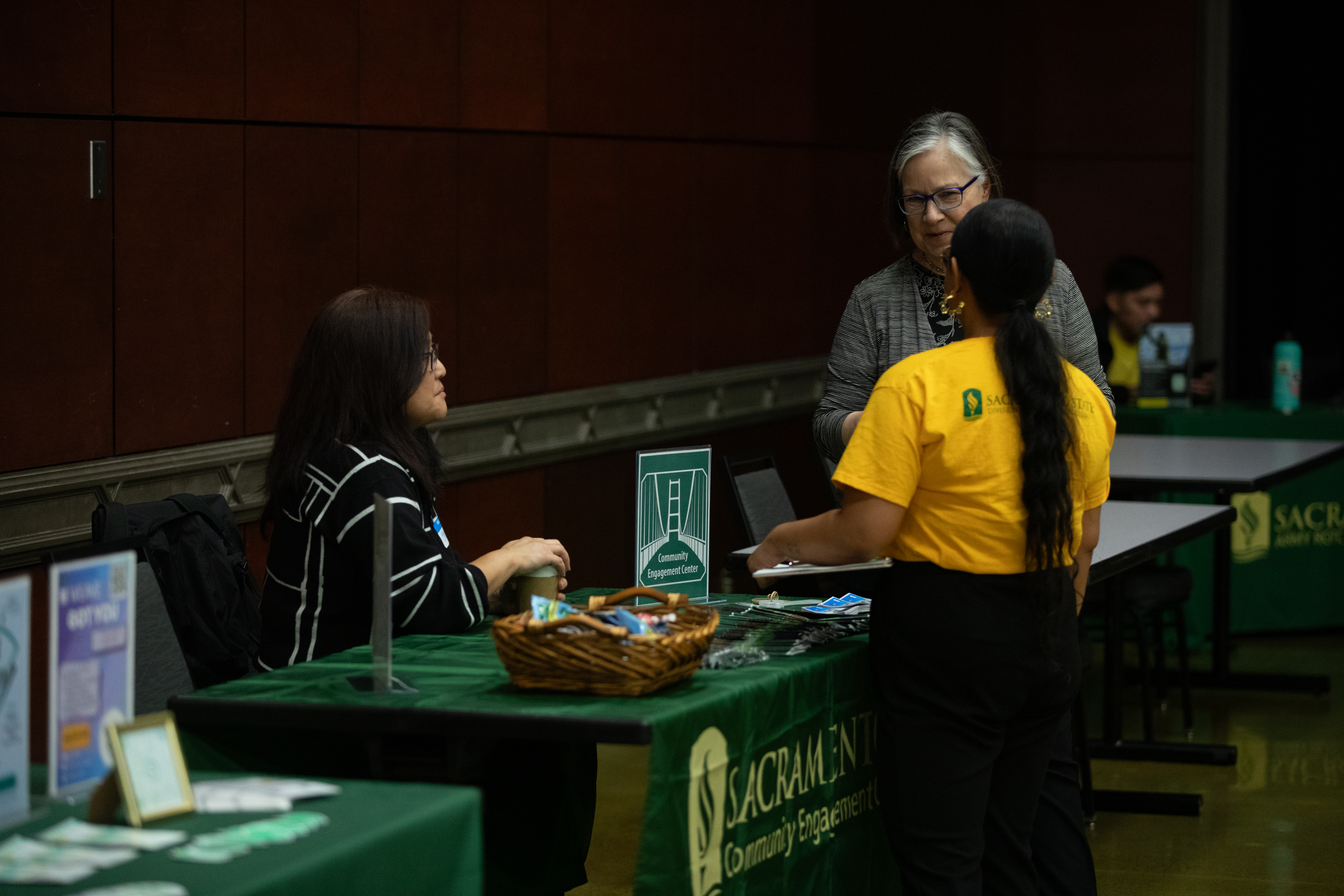 Students and volunteers surround a booth at the resource fair.