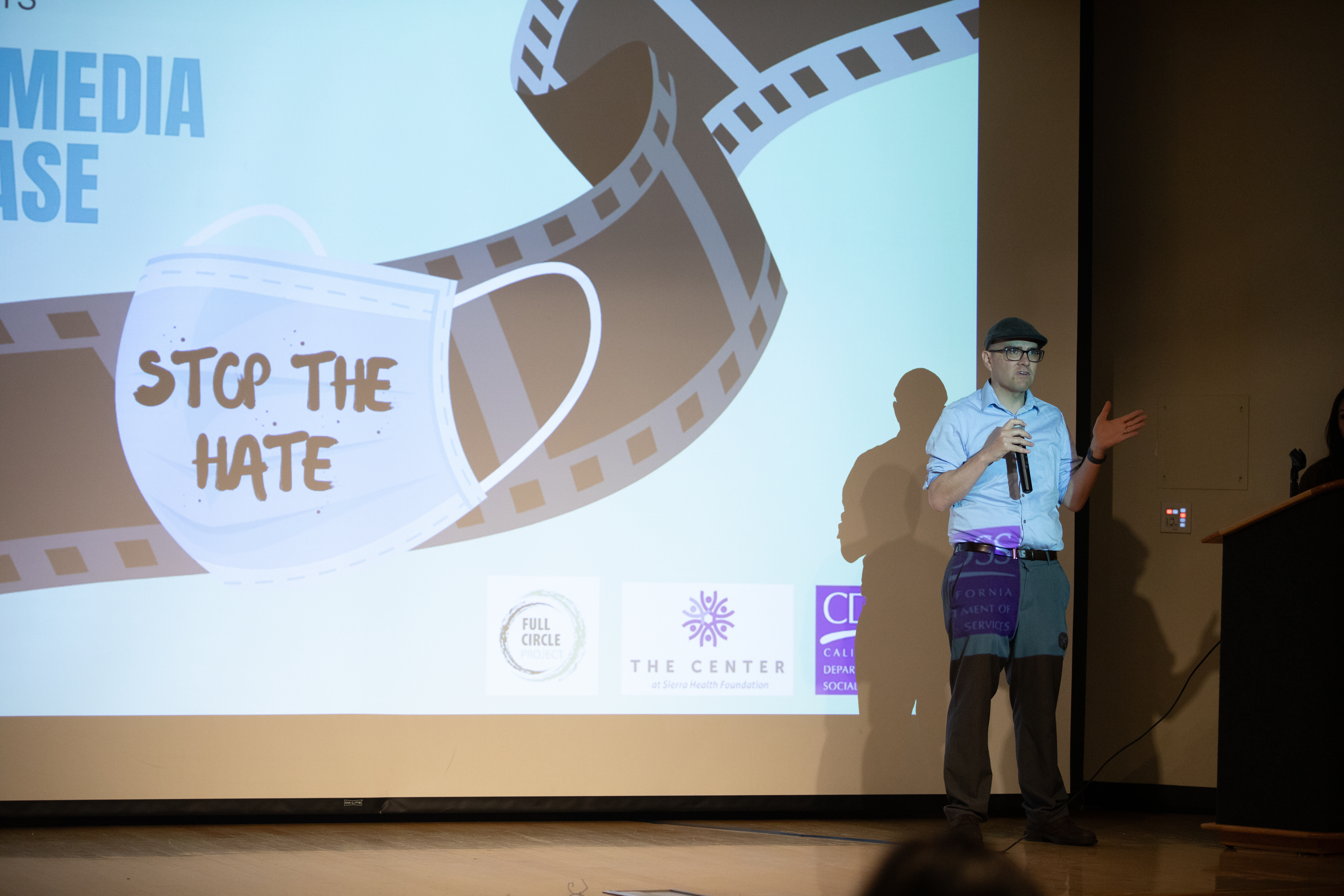 Presenter in front of a movie screen.