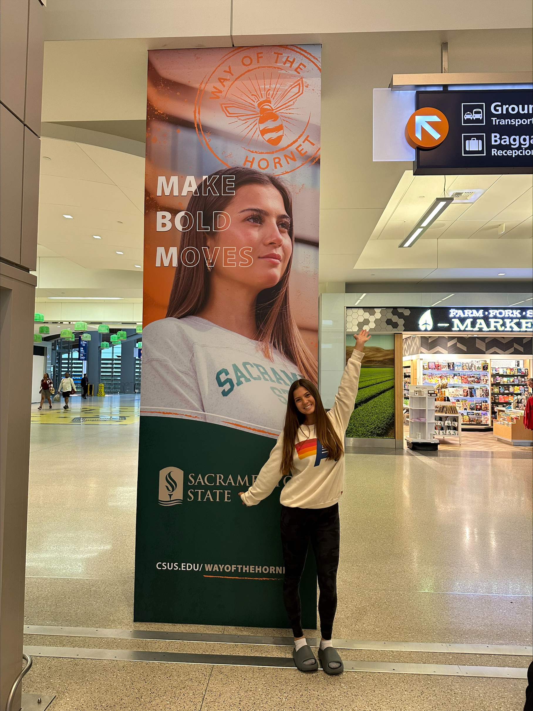 Student posing by airport column