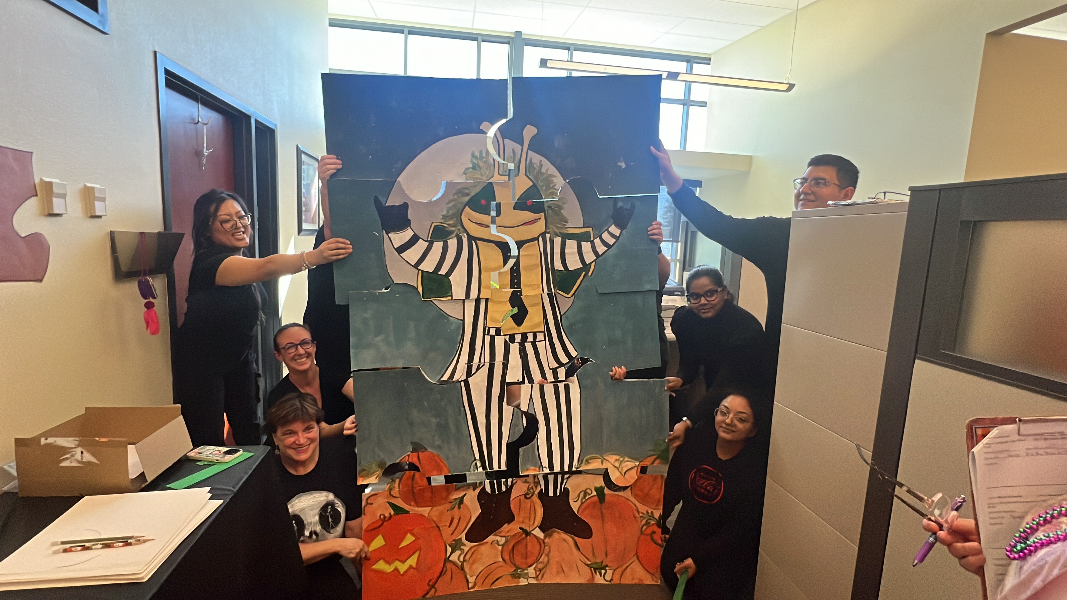 Group holding puzzles pieces up to create Herky Skeleton