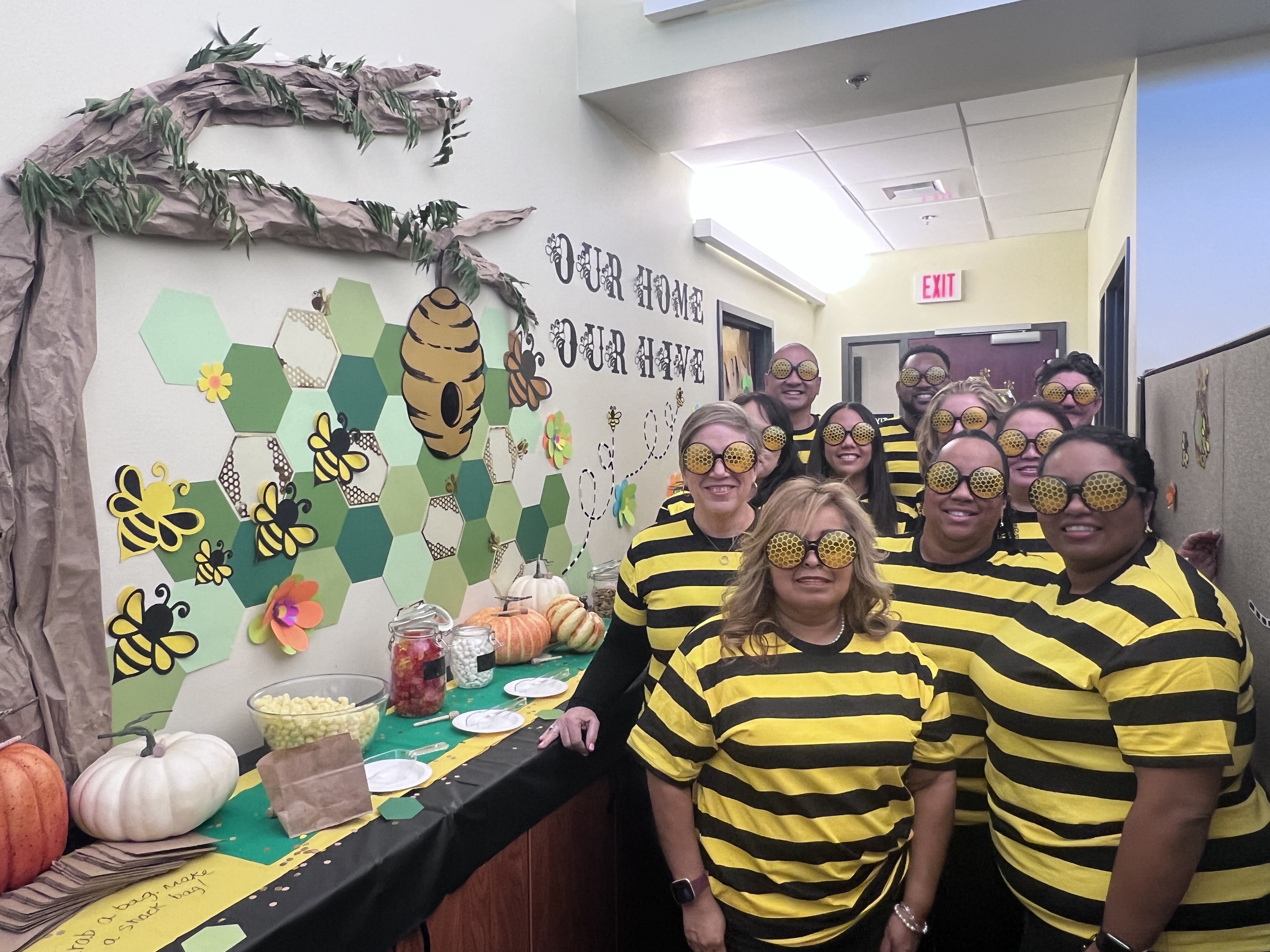 UEI Admin staff dressed in stripped shirts wear bee glasses