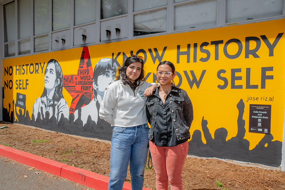 Two women standing together looking at the camera.