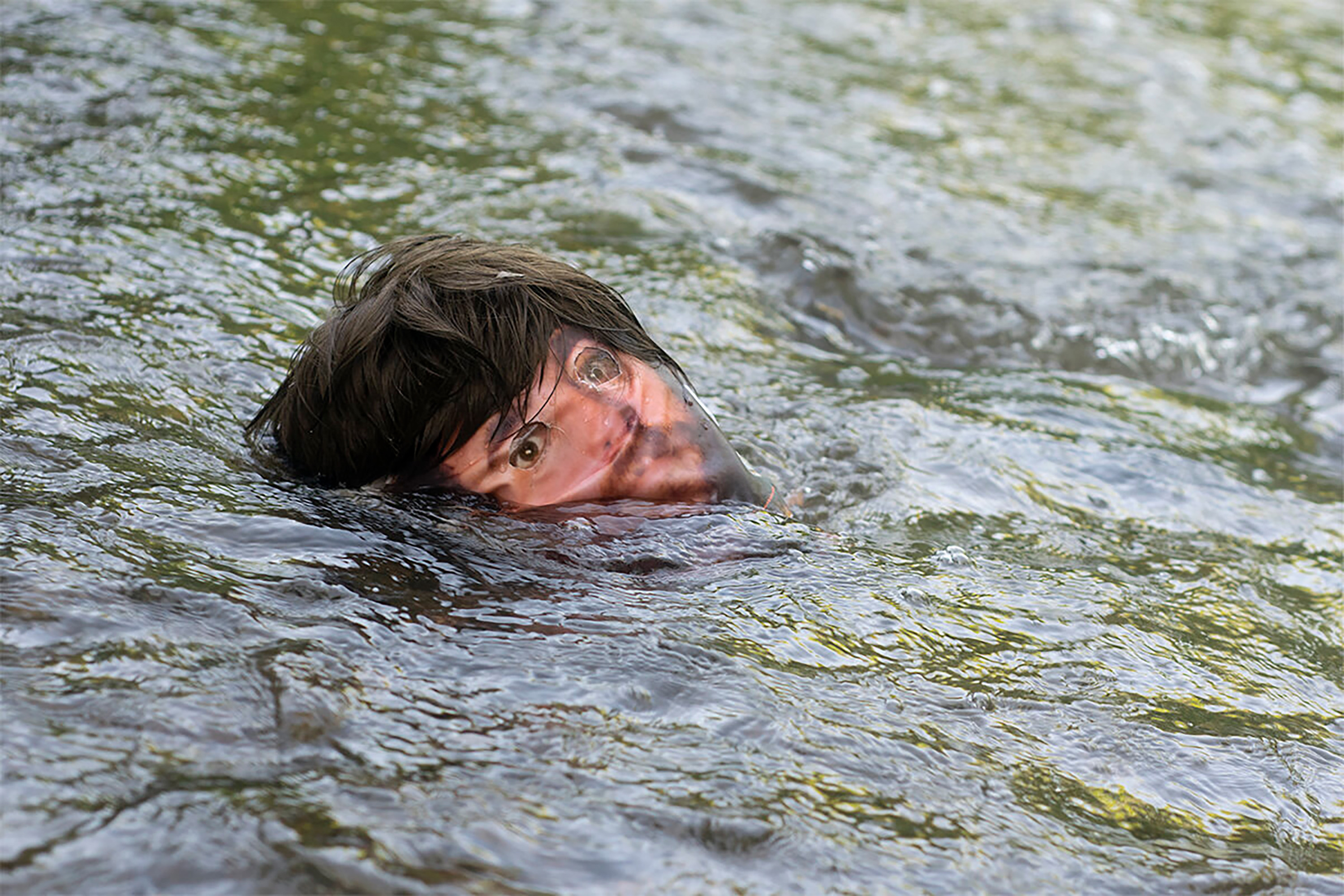 blurred bearded face emerging from water 